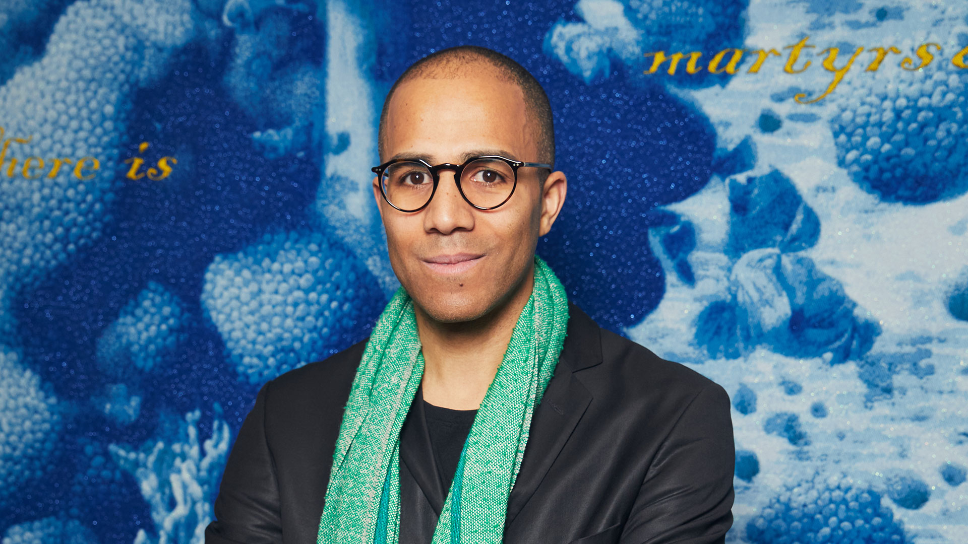Poem Johnson, founder of GrantCraft, in front of one of his Jacquard-woven tapestries